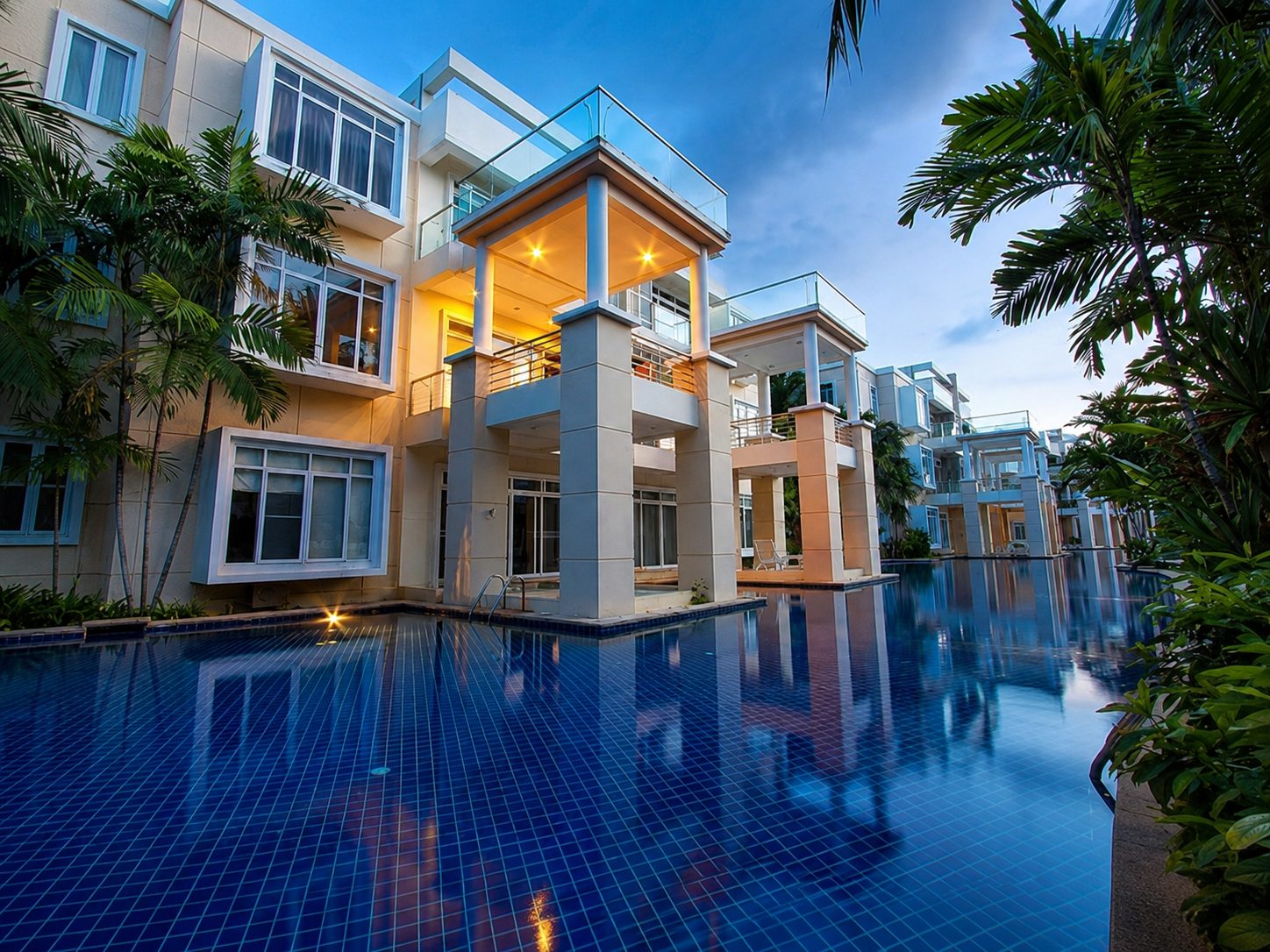 The residence at dusk, warm light in the windows reflecting on the lagoon