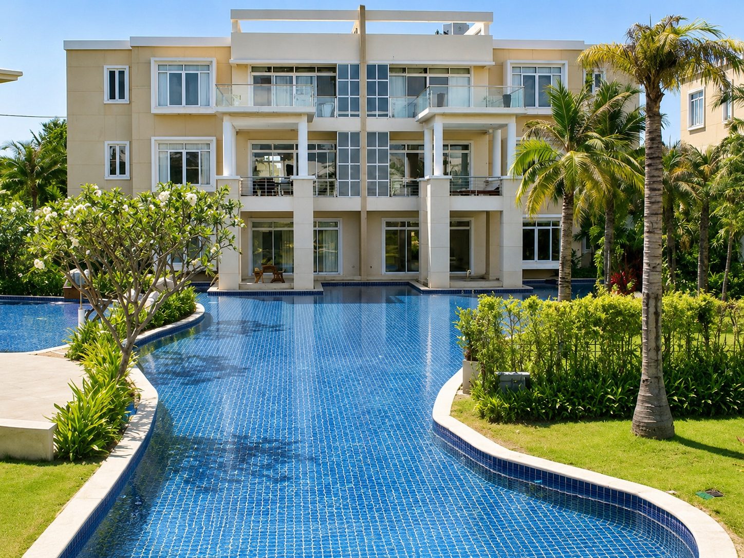 The lagoon pool curving past the Sunvillas building under palms and blue sky